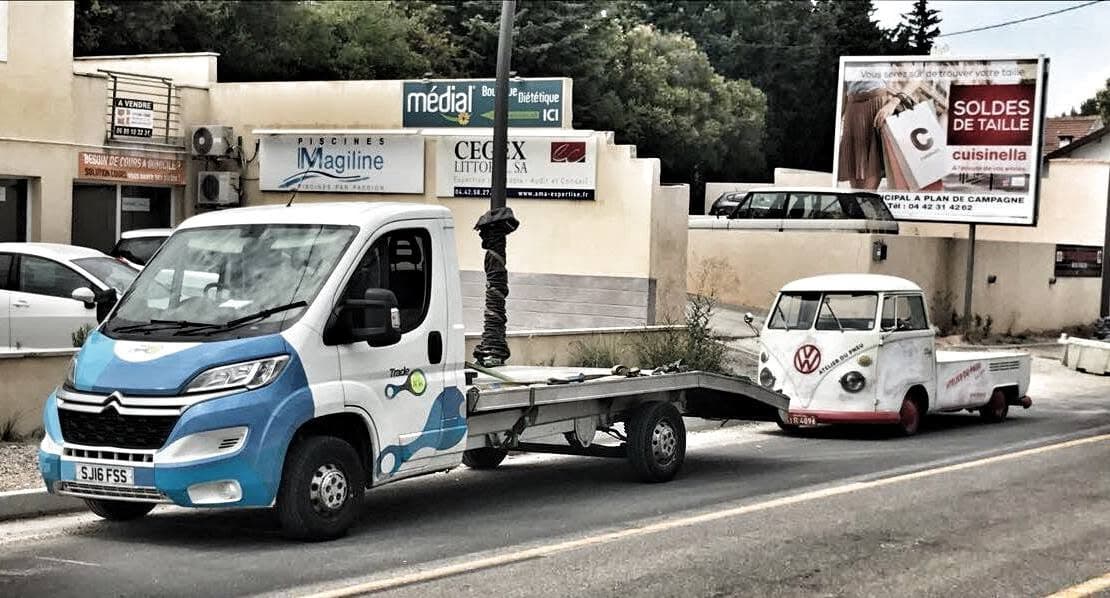Vehicle transporter collecting a classic VW pickup abroad for repatriation to the UK.